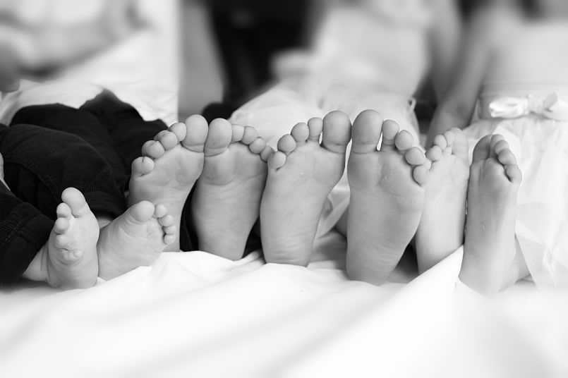 fotografía en blanco y negro de las plantas de los pies de 4 niños